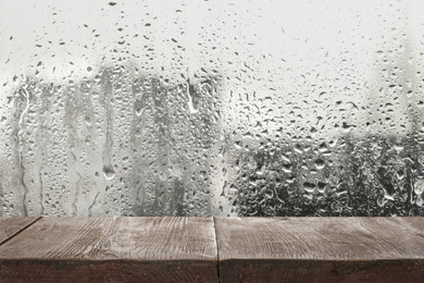 Wooden table near window on rainy day