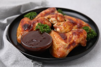 Photo of Fresh marinade and chicken wings on light table, closeup