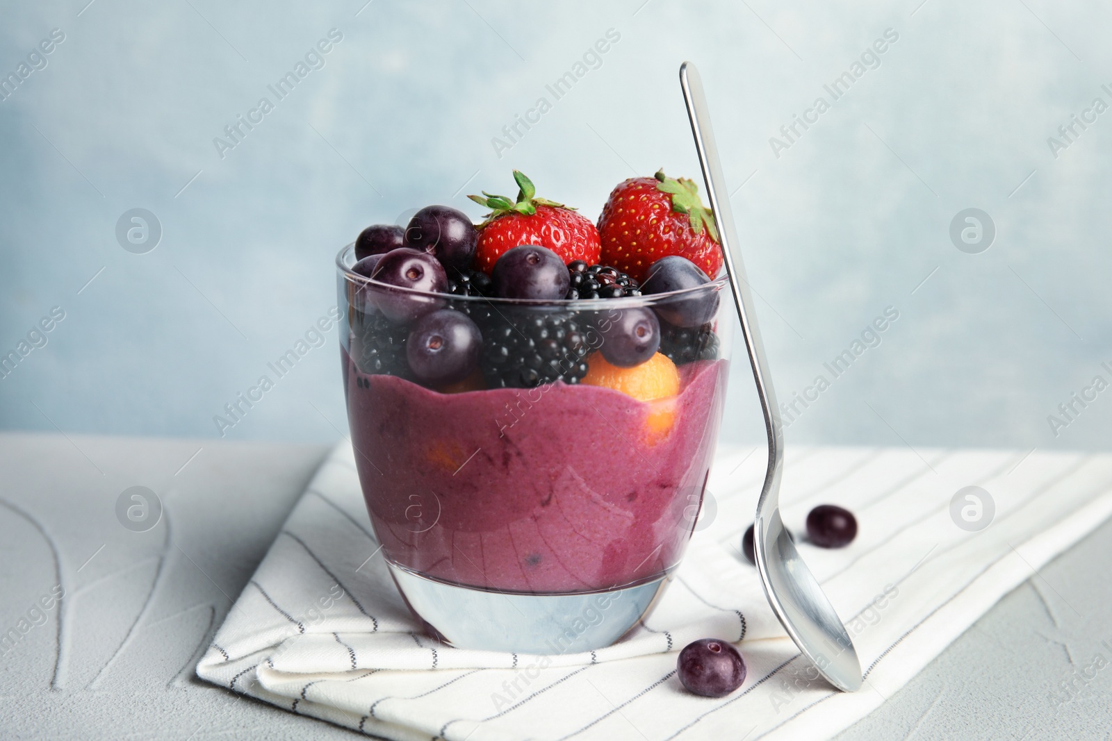 Photo of Glass with tasty acai smoothie on gray table