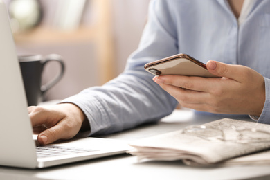 Journalist with smartphone working at table, closeup