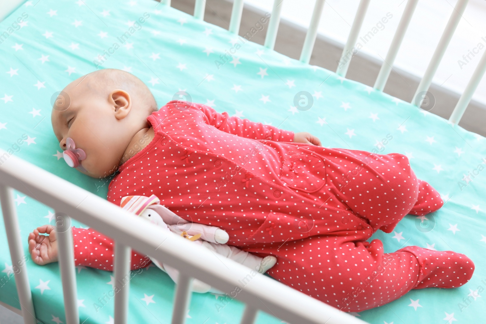 Photo of Cute baby girl sleeping in crib at home