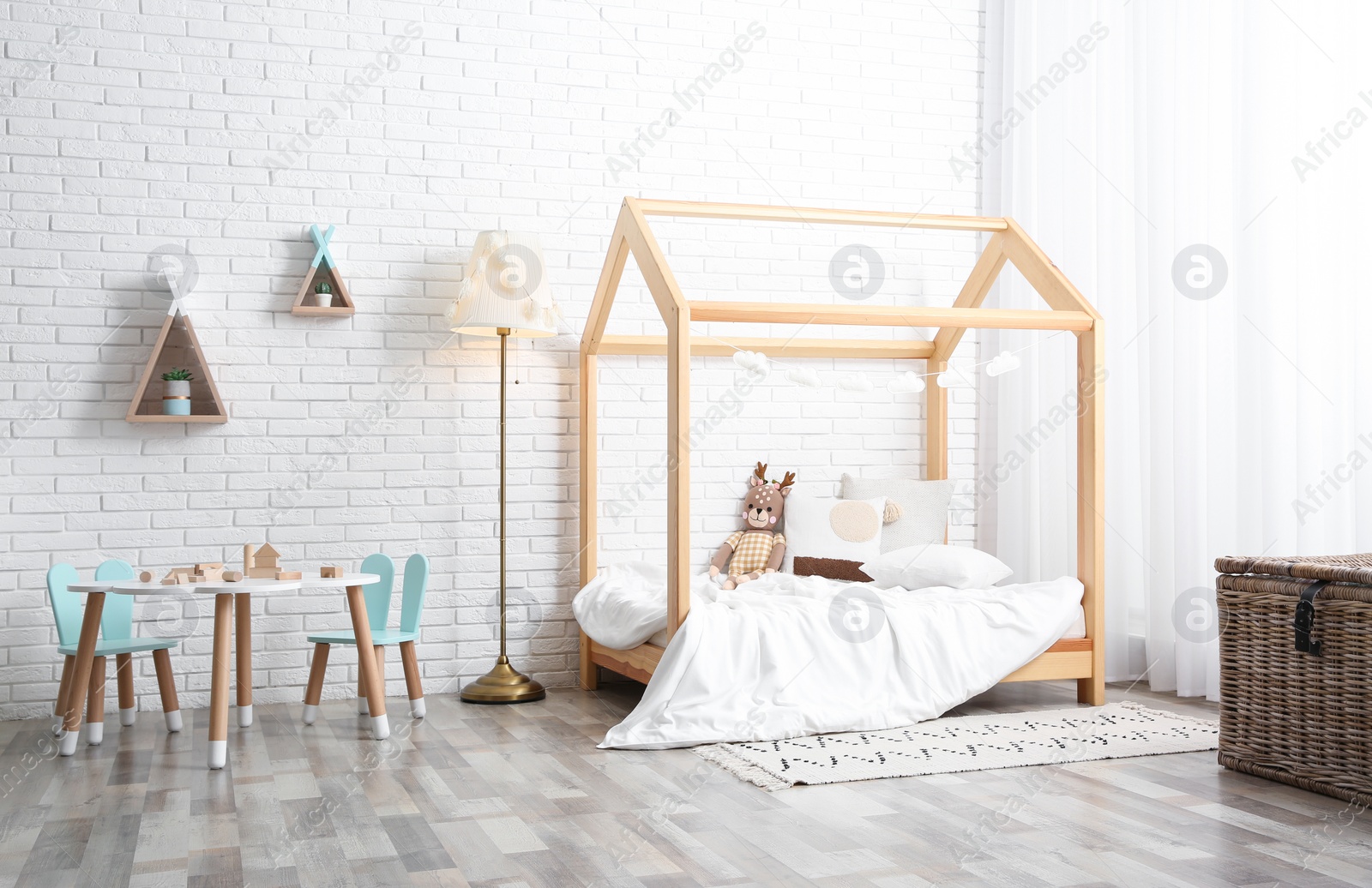 Photo of Cute children's room interior with bed and little table