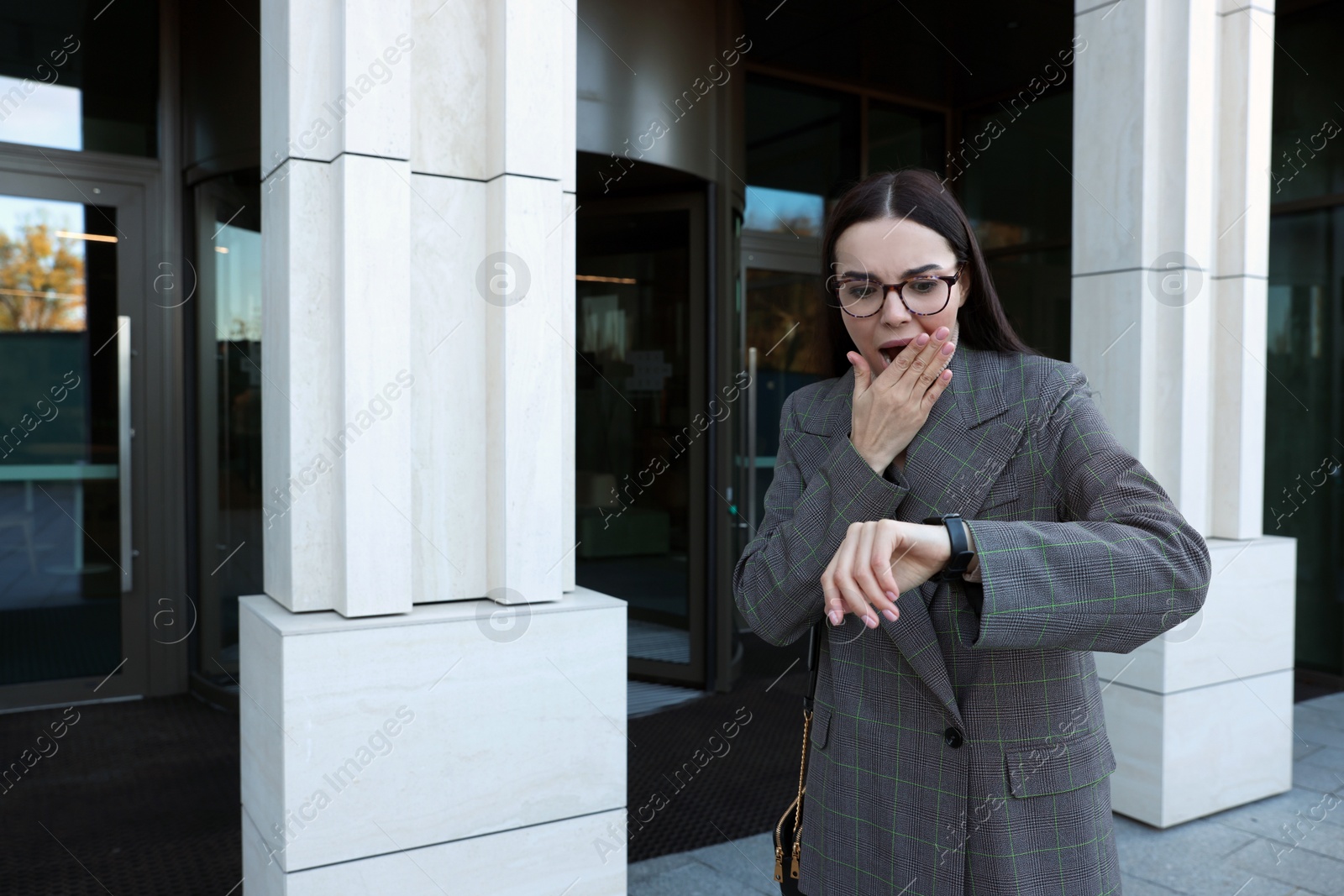 Photo of Emotional woman checking time on watch outdoors. Being late concept