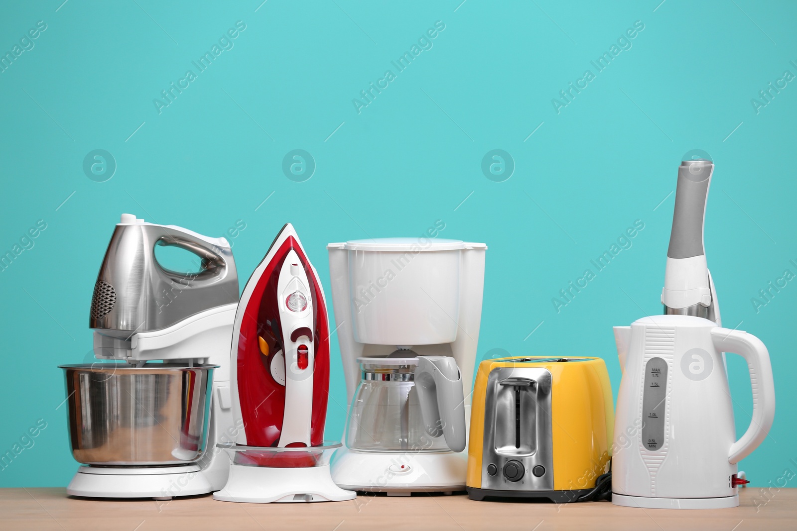 Photo of Household and kitchen appliances on table against color background. Interior element