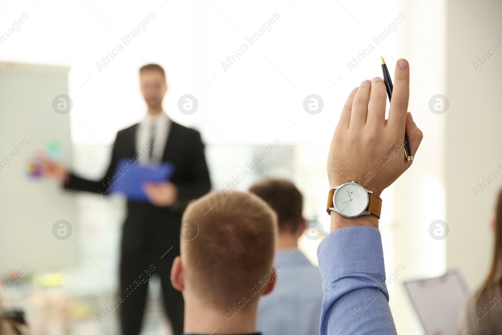 Photo of Man raising hand to ask question at business training indoors, closeup