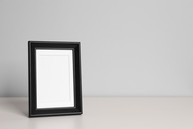 Photo of Empty square frame on white table, space for text