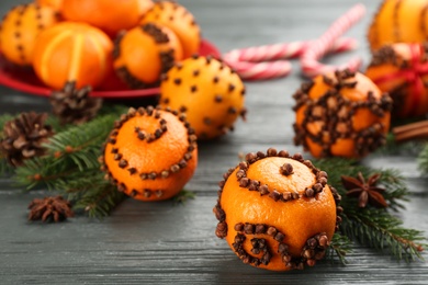 Photo of Pomander ball made of fresh tangerine and cloves on wooden table, space for text