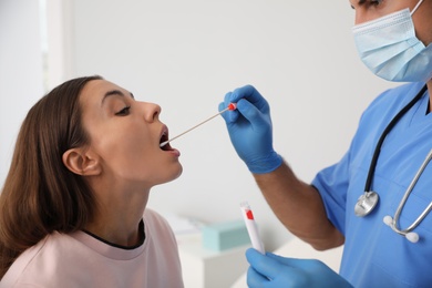 Doctor taking sample for DNA test from woman in clinic