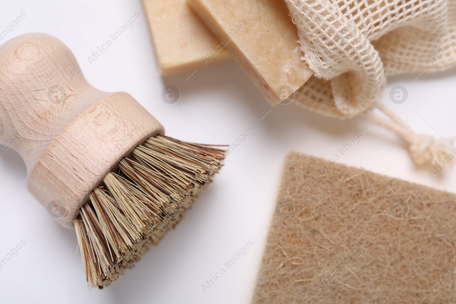 Photo of Cleaning brush, sponge and soap bars on white background, flat lay