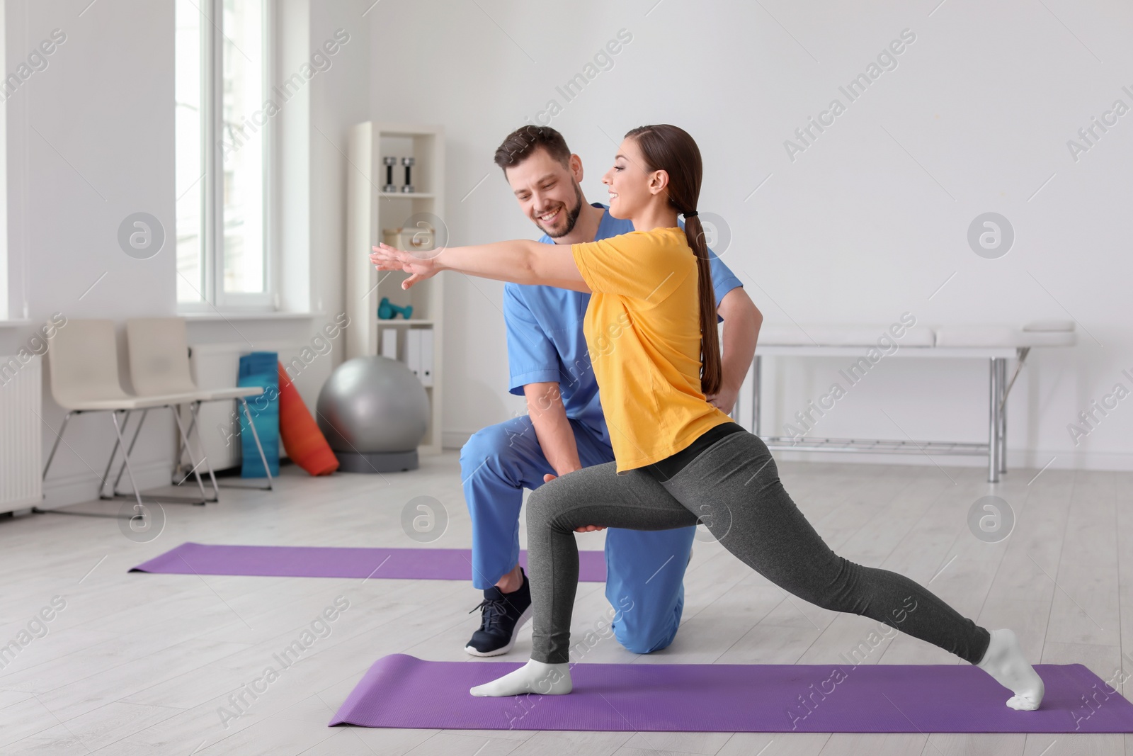 Photo of Physiotherapist working with female patient in clinic