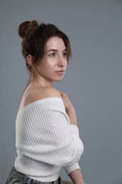 Portrait of beautiful young woman on grey background