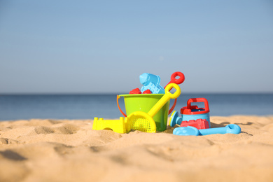 Photo of Different child plastic toys on sandy beach