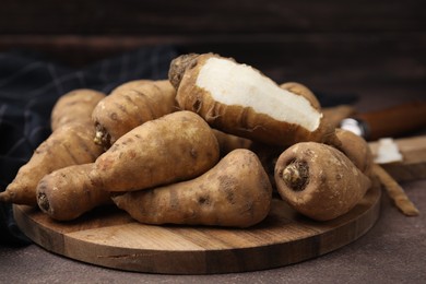 Photo of Tubers of turnip rooted chervil on brown table, closeup