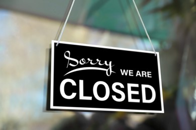 Image of Sorry we are closed sign hanging on glass door