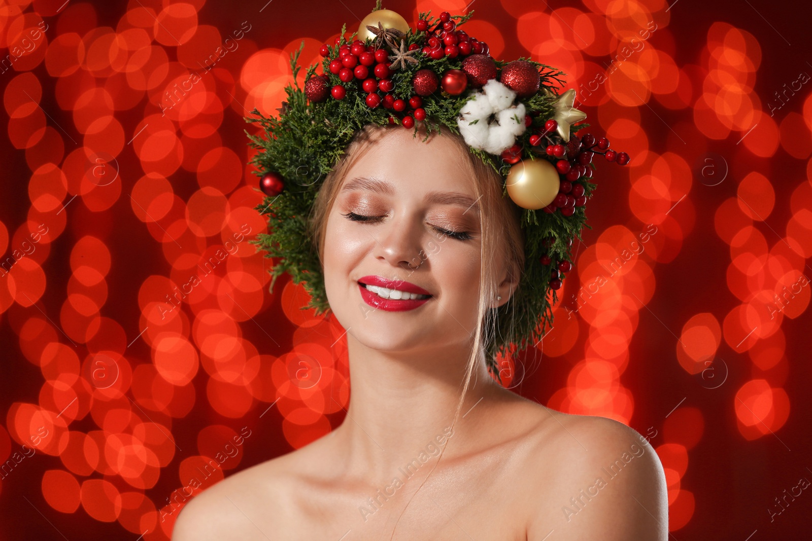 Photo of Beautiful young woman wearing Christmas wreath on blurred background. Bokeh effect