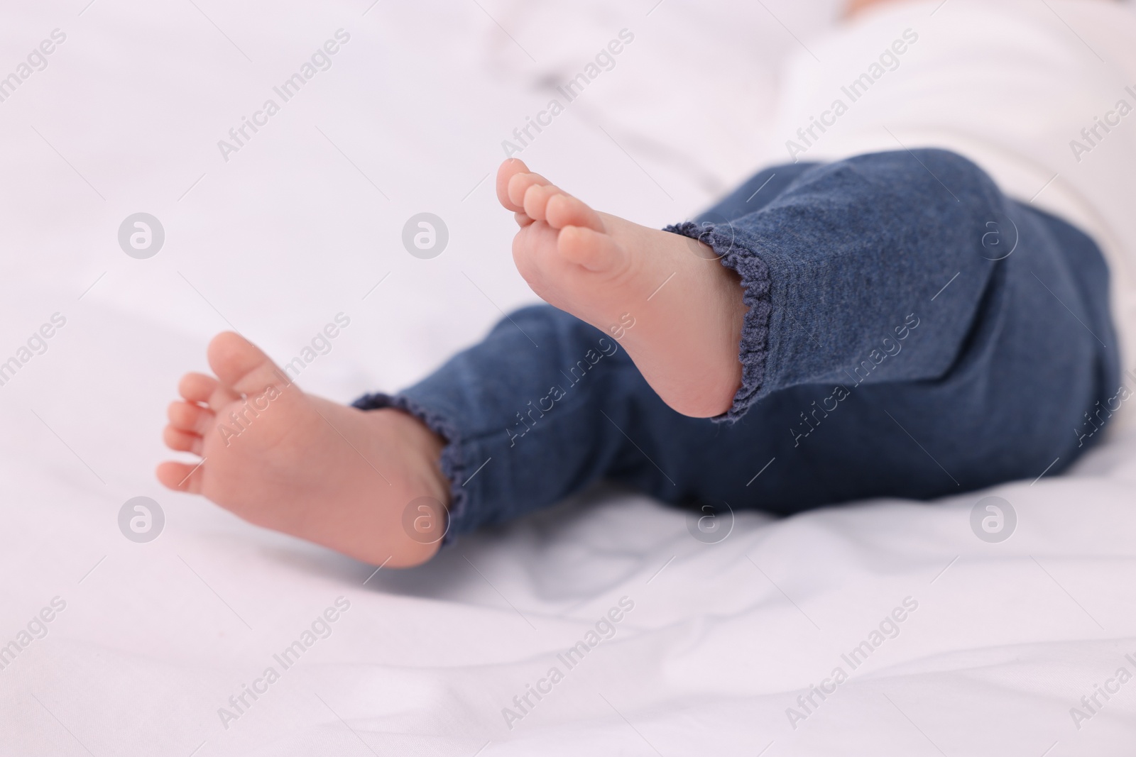 Photo of Newborn baby lying on white blanket, closeup