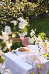 Photo of Stylish table setting with beautiful spring flowers in garden