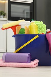 Photo of Different cleaning supplies in bucket on floor