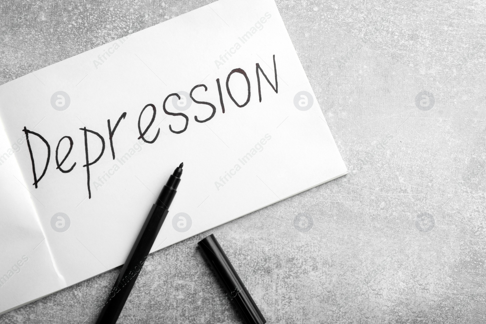 Photo of Sheet of paper with word Depression and black felt tip pen on light grey table, flat lay. Space for text