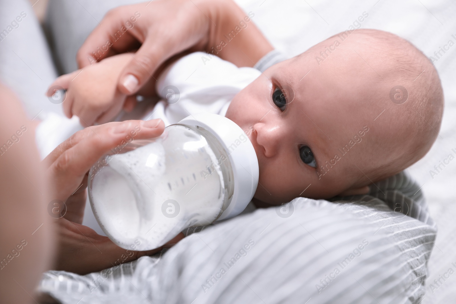 Photo of Mother feeding her little baby from bottle, closeup