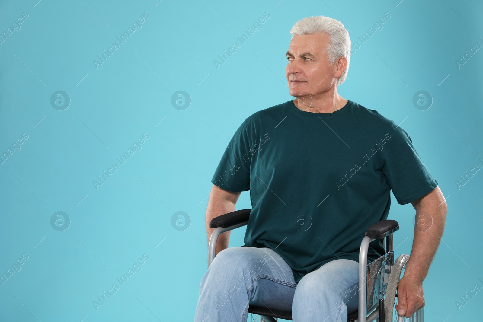 Photo of Senior man in wheelchair on color background. Space for text