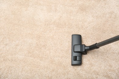 Removing dirt from carpet with vacuum cleaner indoors, top view. Space for text