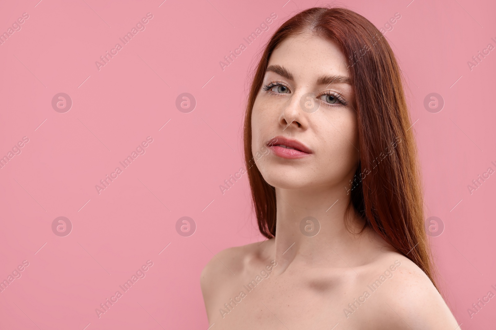 Photo of Portrait of beautiful woman with freckles on pink background. Space for text