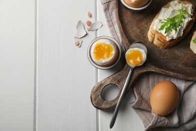 Breakfast with soft boiled egg served on white wooden table, flat lay. Space for text