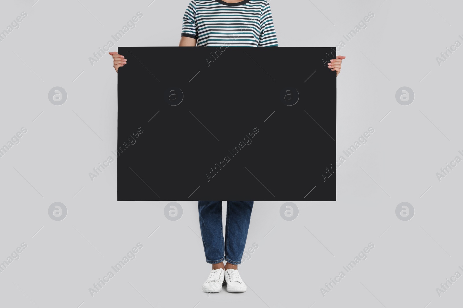 Photo of Woman holding blank poster on light grey background, closeup