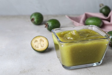 Photo of Feijoa jam on light grey table, closeup. Space for text