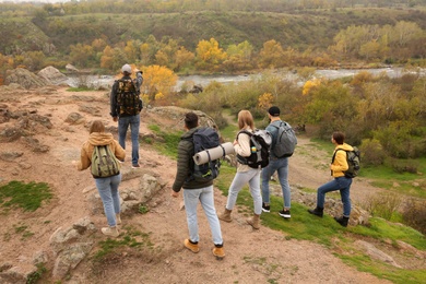 Photo of Group of hikers with backpacks climbing up mountains