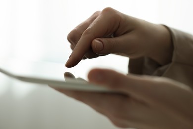 Closeup view of woman using modern tablet on blurred background
