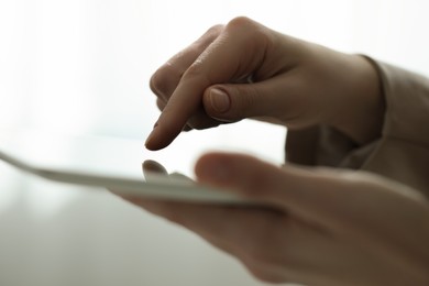 Photo of Closeup view of woman using modern tablet on blurred background