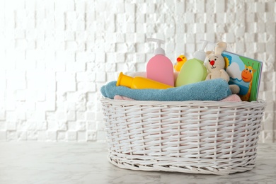 Photo of Basket with different baby accessories on table. Space for text