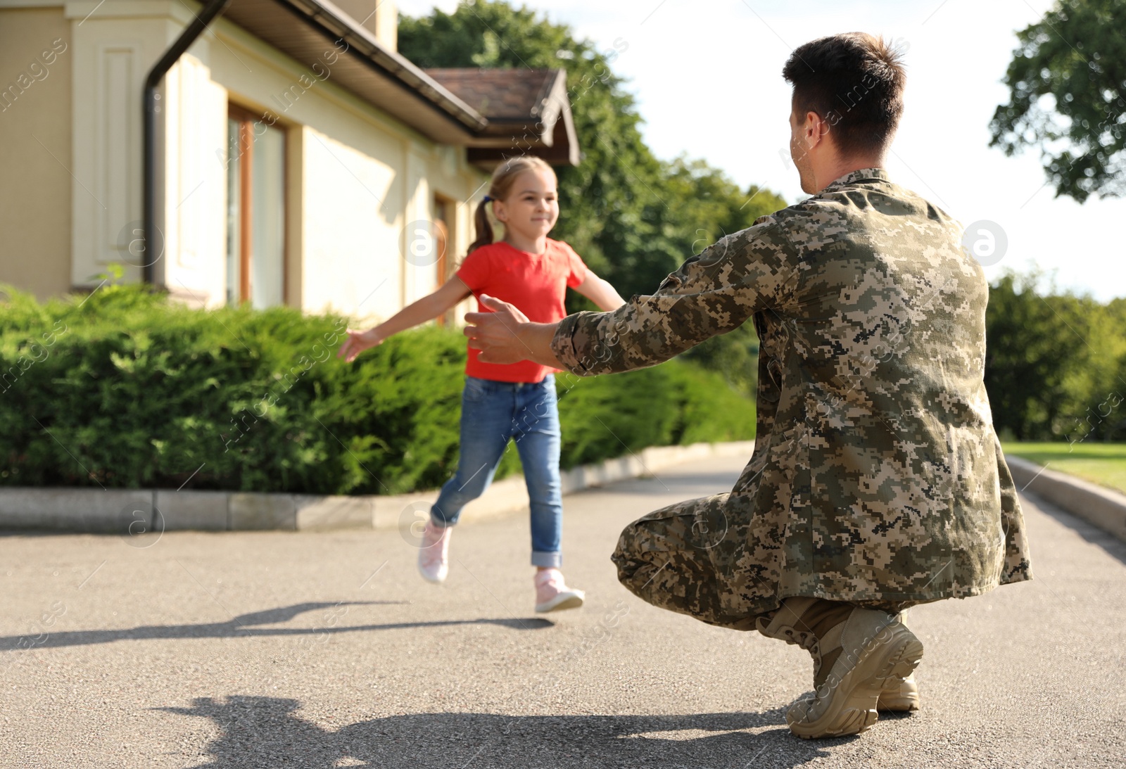 Photo of Father in military uniform and little daughter running to him outdoors