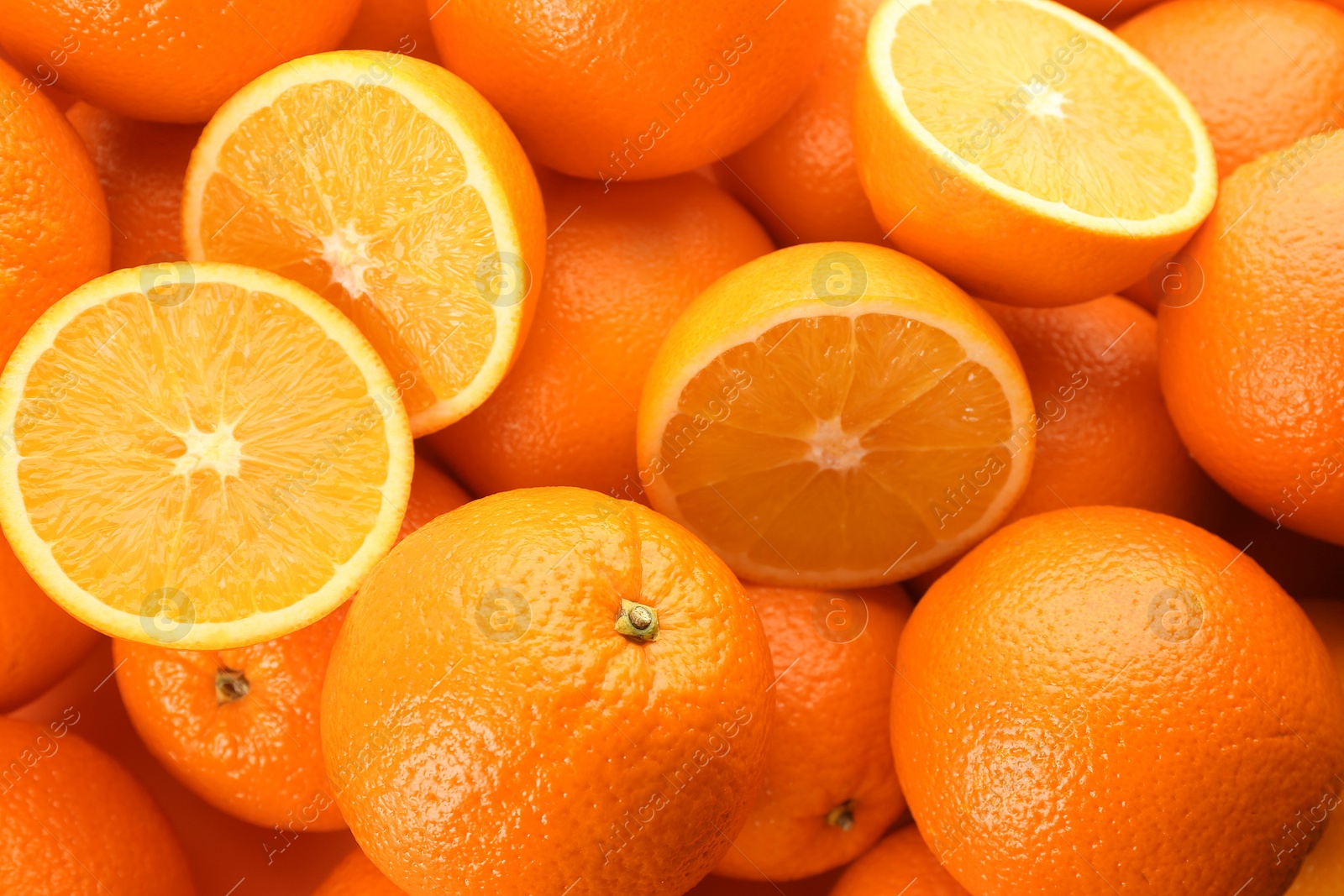 Photo of Cut and whole fresh ripe oranges as background, top view