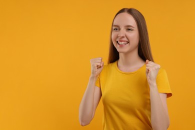 Photo of Emotional sports fan celebrating on yellow background. Space for text