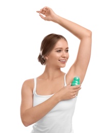 Young woman applying deodorant to armpit on white background