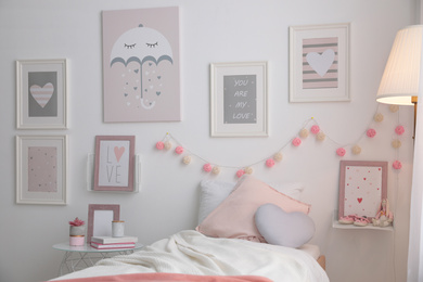 Stylish child's room interior with beautiful pictures and comfortable bed