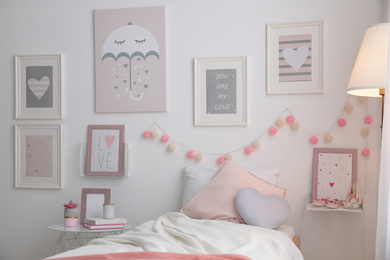 Photo of Stylish child's room interior with beautiful pictures and comfortable bed