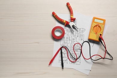 Wiring diagrams, digital multimeter and tools on white wooden table, flat lay. Space for text