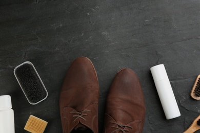 Photo of Stylish footwear with shoe care accessories on black table, flat lay. Space for text