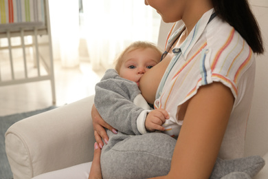 Woman breastfeeding her little baby at home