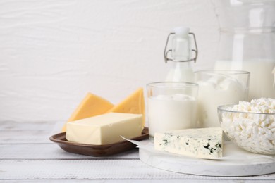 Photo of Different fresh dairy products on white wooden table. Space for text