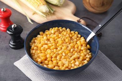 Photo of Bowl with corn kernels on grey table