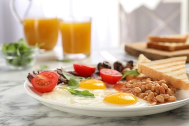 Tasty breakfast with fried eggs on white marble table, closeup