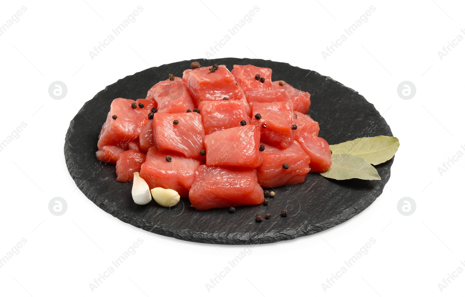 Photo of Pieces of raw beef, garlic, bay leaves and peppercorns isolated on white