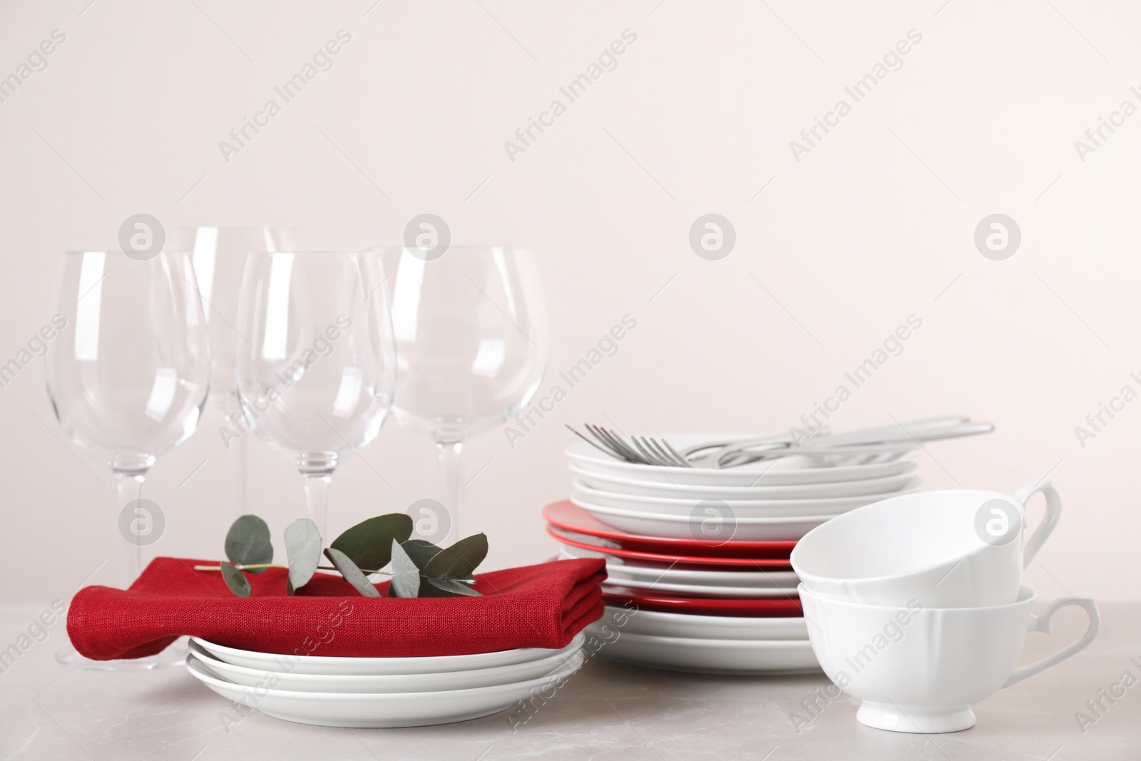Photo of Set of clean tableware on light grey marble table