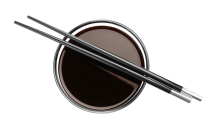 Bowl of soy sauce with chopsticks on white background, top view