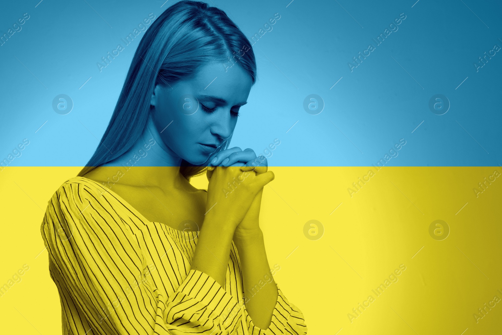 Image of Pray for Ukraine. Double exposure of young woman praying and Ukrainian national flag